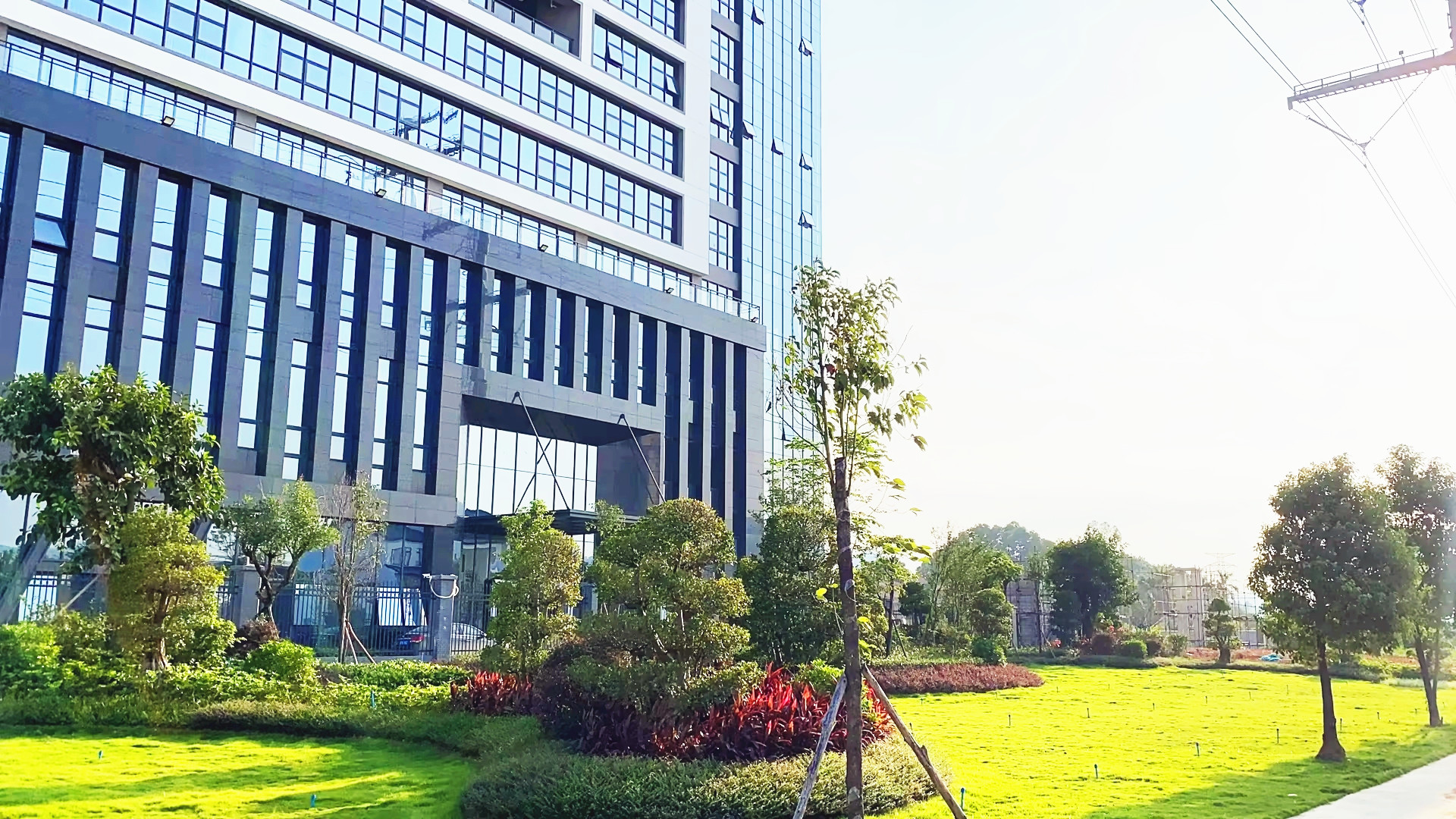 Modern electronics manufacturing facility interior with advanced production equipment, workers in cleanroom suits operating machinery, showcasing high-tech manufacturing environment